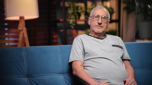 Senior Man Sitting Comfortably on Couch Indoors