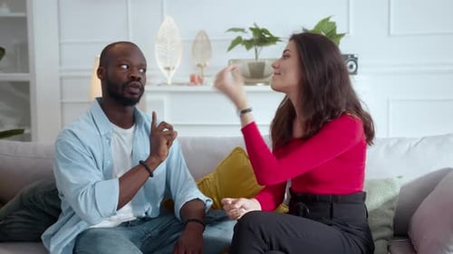 Un homme et une femme sur un canapé partagent une conversation animée et chaleureuse