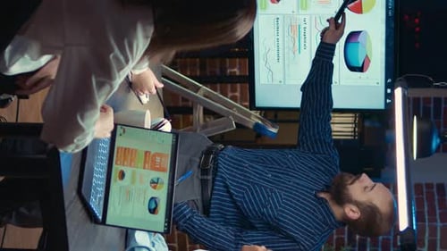 Adults Analyze Data in Urban Office at Night