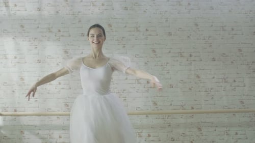Elegant Ballerina Dancing Gracefully in Studio Wearing White
