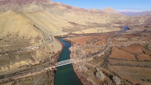 Aerial view bridge crosses a river in a mountain landscape