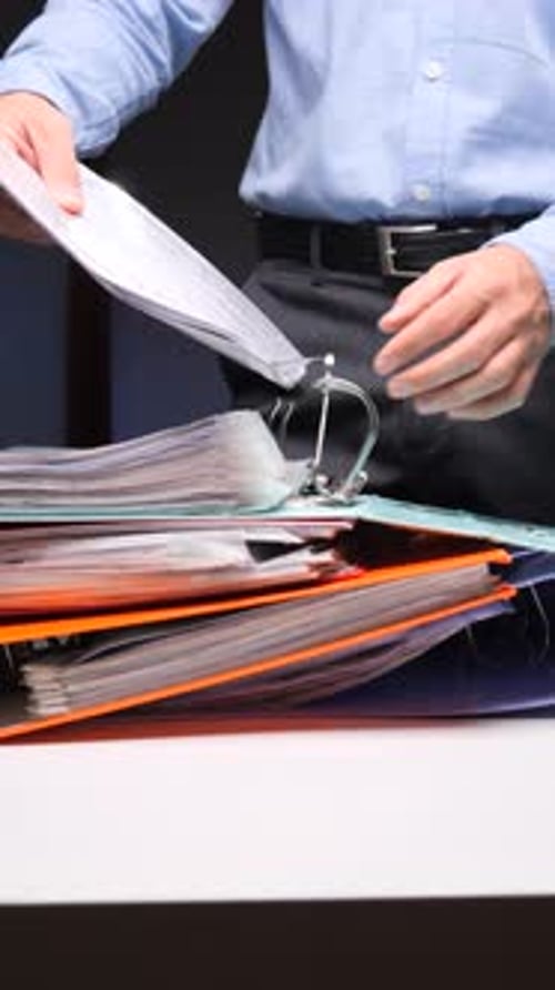 Vertical Video Person Filing Documents in a Full Office Binder