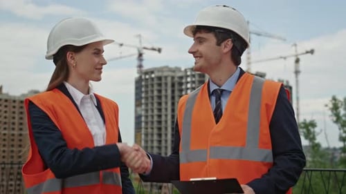 Engineers Collaborate Building Strategy Shaking Hands at Urban Worksite Closeup
