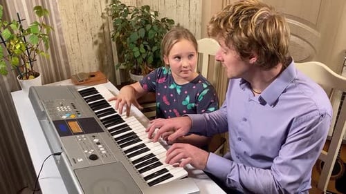 Child and Adult Playing Electronic Keyboard