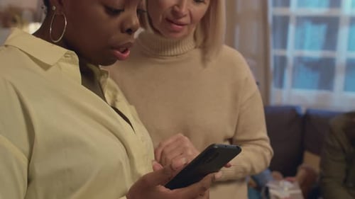 Interkulturelle Frauen schauen sich etwas auf dem Smartphone an