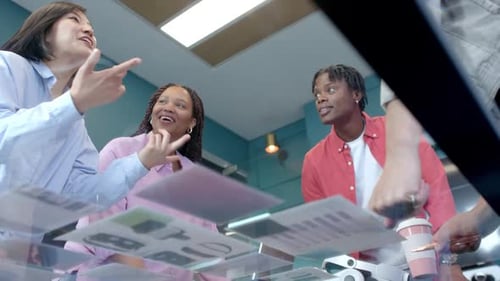 Discussing project ideas, diverse colleagues collaborating and smiling in modern office