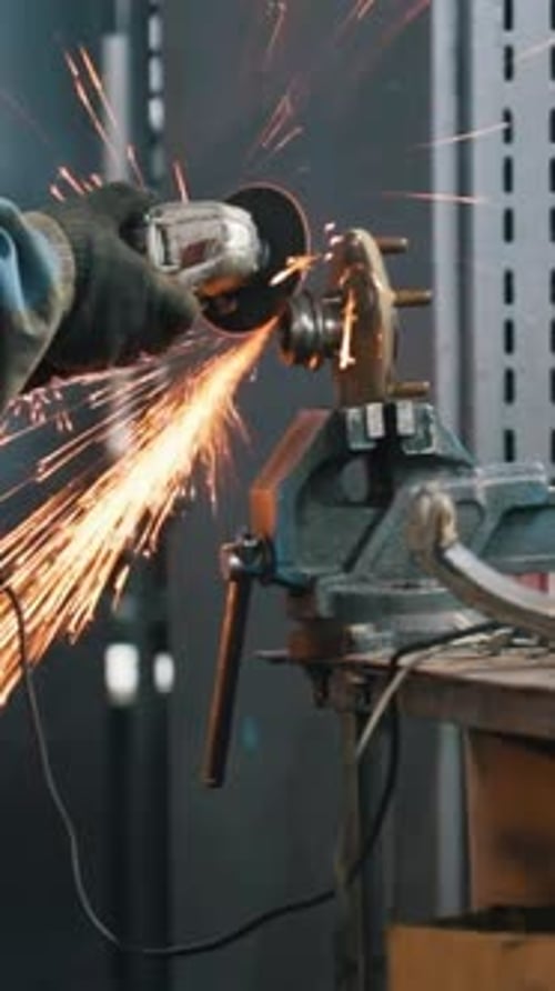 Car Auto Service Worker Grinding Metal Construction with a Circular