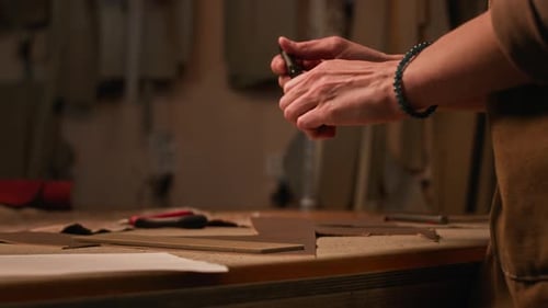 Leather Crafter Tracing and Cutting Material at Table