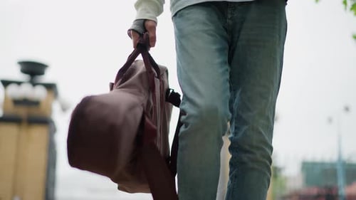 Music Performer with Instrument Strolls Through City Street Performer Equipped with Musical Tools
