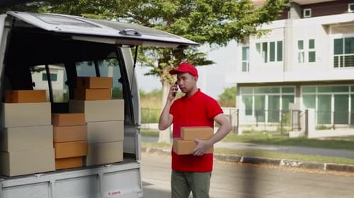 Delivery man, driver calling to customerr for sending parcel box package in the cargo truck at home