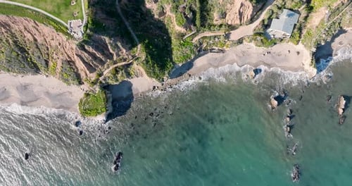 Aerial top view of ocean blue waves break on a beach.