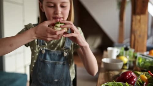 Child Eating Sandwich in Kitchen