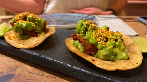 Picking up a tasty memela with pancita confitada and spicy green salsa sauce, traditional mexican cu