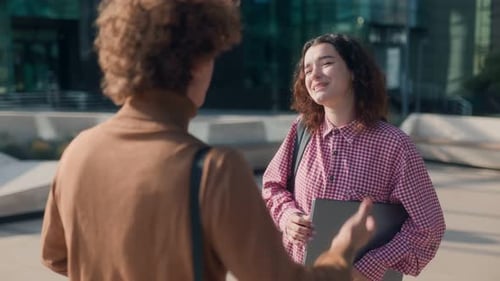 Happy Young Man and Woman Students Talking Casually Outside University