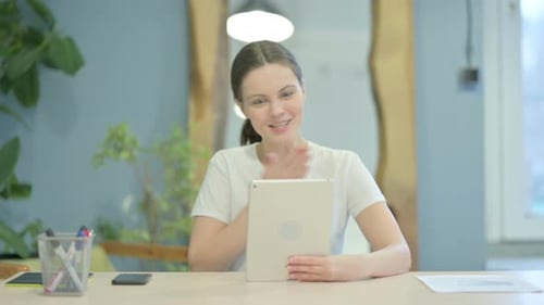 Woman Using Tablet for Video Call at Desk