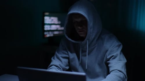 Porträt eines fokussierten Hackers, der eine Online-Website hackt oder sich in Sicherheitssysteme einfügt unter