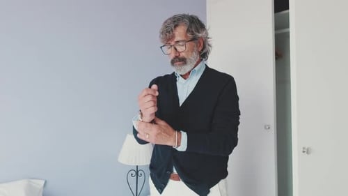 Man Adjusts Clothes in Bedroom