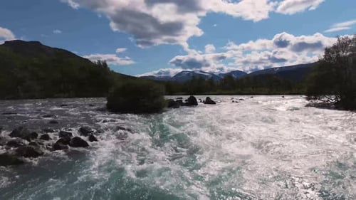 Aerial view of a beautiful river with crystal clear water, surrounded by mountains and lush vegetati