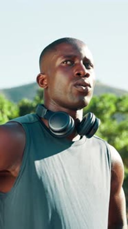 Young Man Wearing Headphones Outside on Sunny Day