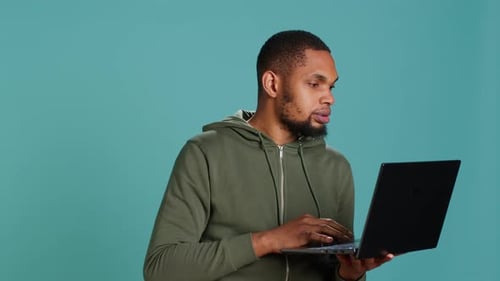 Человек, печатающий на клавиатуре ноутбука и проверяющий электронную почту, обрадован хорошими новостями