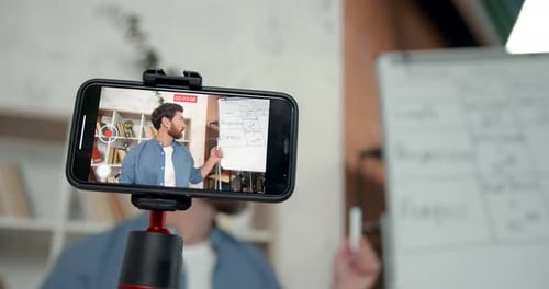Man Recording Lecture on Phone at Home