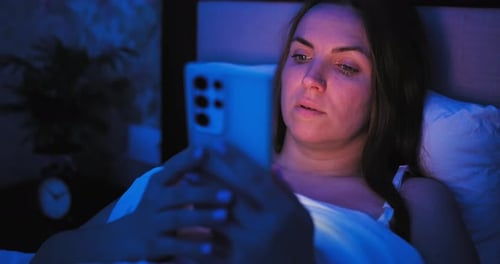 Woman in Bed Uses Mobile Phone at Night