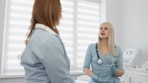 Doctor with Tablet Consulting Female Patient in Hospital