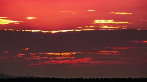 Timelapse Dramatic Sunset with Sun Rays in the Sky Through Orange Layered Clouds