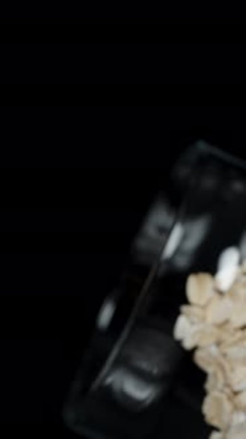 Oat Flakes Poured into Clear Bowl Close-up