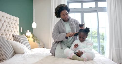Mother Brushing Child's Hair on Bed