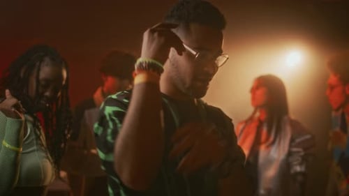 Bärtiger Typ mit Brille tanzt entspannt zu EDM im Nachtclub