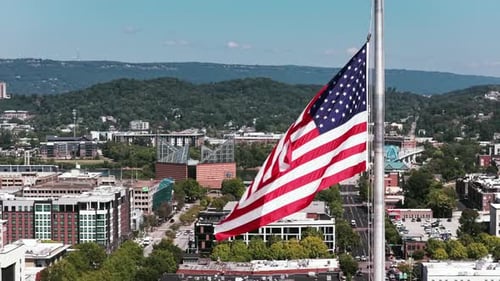 American Flag Waving Over City on Sunny Day