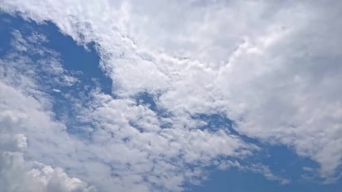 Fluffy White Clouds Moving Across a Blue Sky