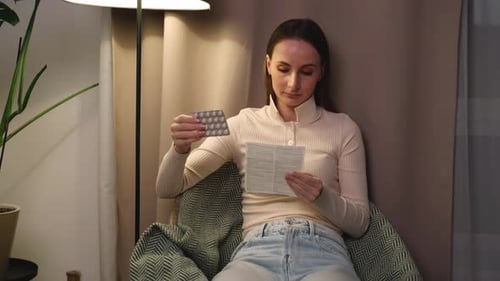 A Woman Taking Pills and Reading Instructions Medical Rehabilitation and a Pharmacy Box with Pills