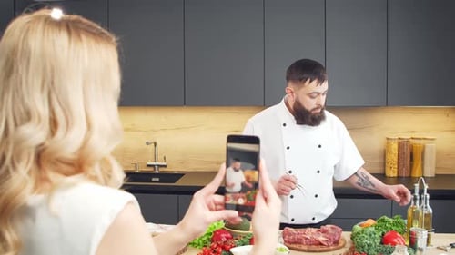 Junge Frau und Mann bereiten Essen zu und veranstalten eine Kochshow, die Blogger aus Kitchen Healthy streamen