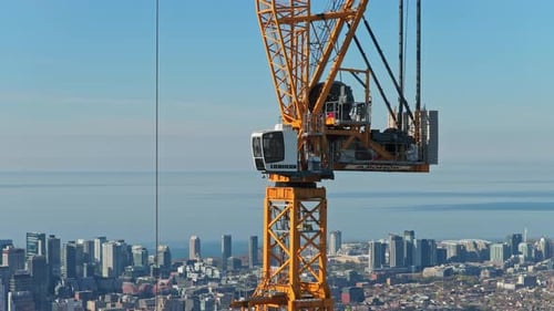 Cabine de grue de construction opérant au-dessus du centre-ville avec la ligne d'horizon de la ville en arrière-plan symbolisant