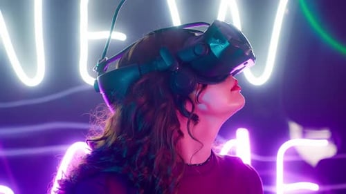 Woman Immersed in VR Headset With Neon Lights