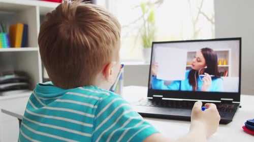 Child Attends Virtual Lesson at Home with Laptop