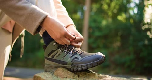 Person, hands and tying with shoes for hiking preparation, walk or outdoor journey in nature