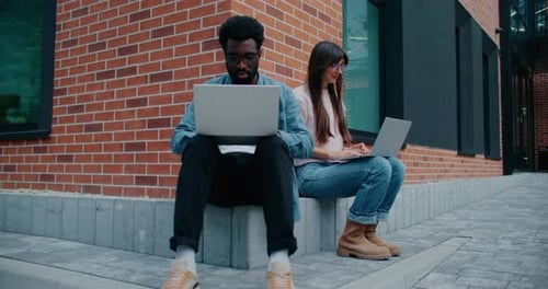 Camera Focus on African American Student Sitting Next to His Friend People Writing Something on