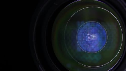 Moving Light Source On Video Camera Lens in the Dark. Close Up.