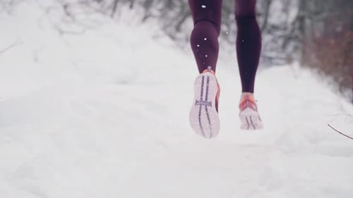 Woman Running Through a Snowy Winter Landscape