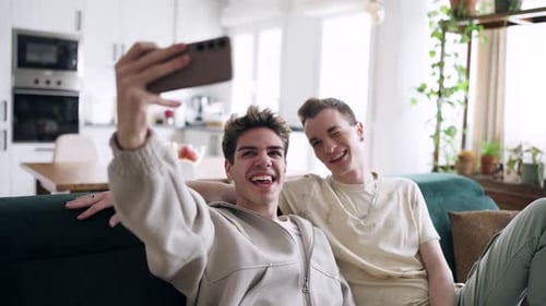 Smiling Young Men Taking Selfie on Couch Together