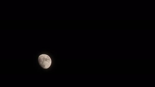 Time lapse of moon at night with a copy space. Half moon with detail surface.