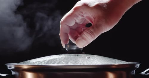 Slow motion of hot pot or shabu-shabu pot made of stainless steel with a glass lid, water boiling,