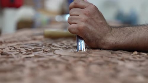 Craftsman Carving Intricate Wood Design with Chisel Tool