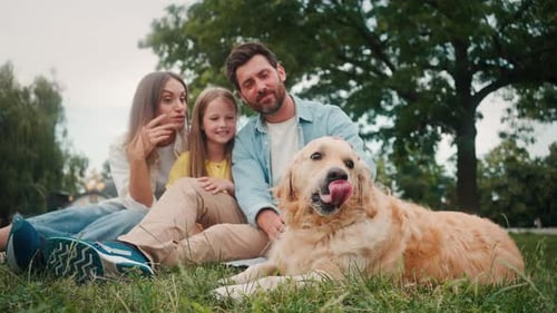 Family Petting Dog Outdoors in a Green Park