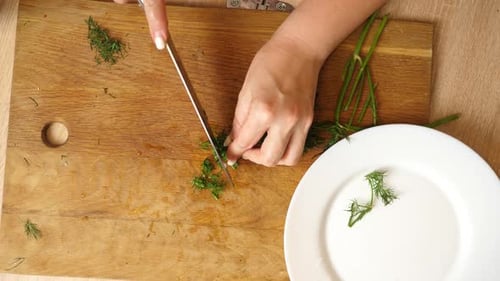 10Dill wird mit einem Messer fein gehackt. Gerichte aus Gemüse kochen.