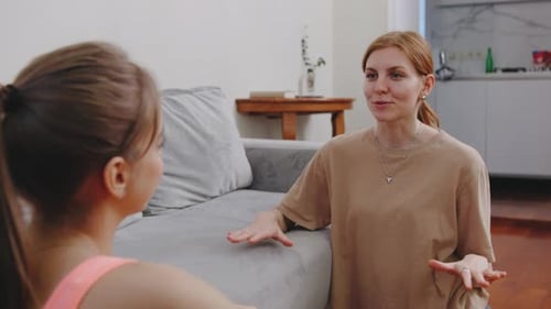 Two People Talking Indoors on a Floor