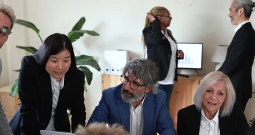 Multiracial business team collaborates on startup strategy inside modern bank office